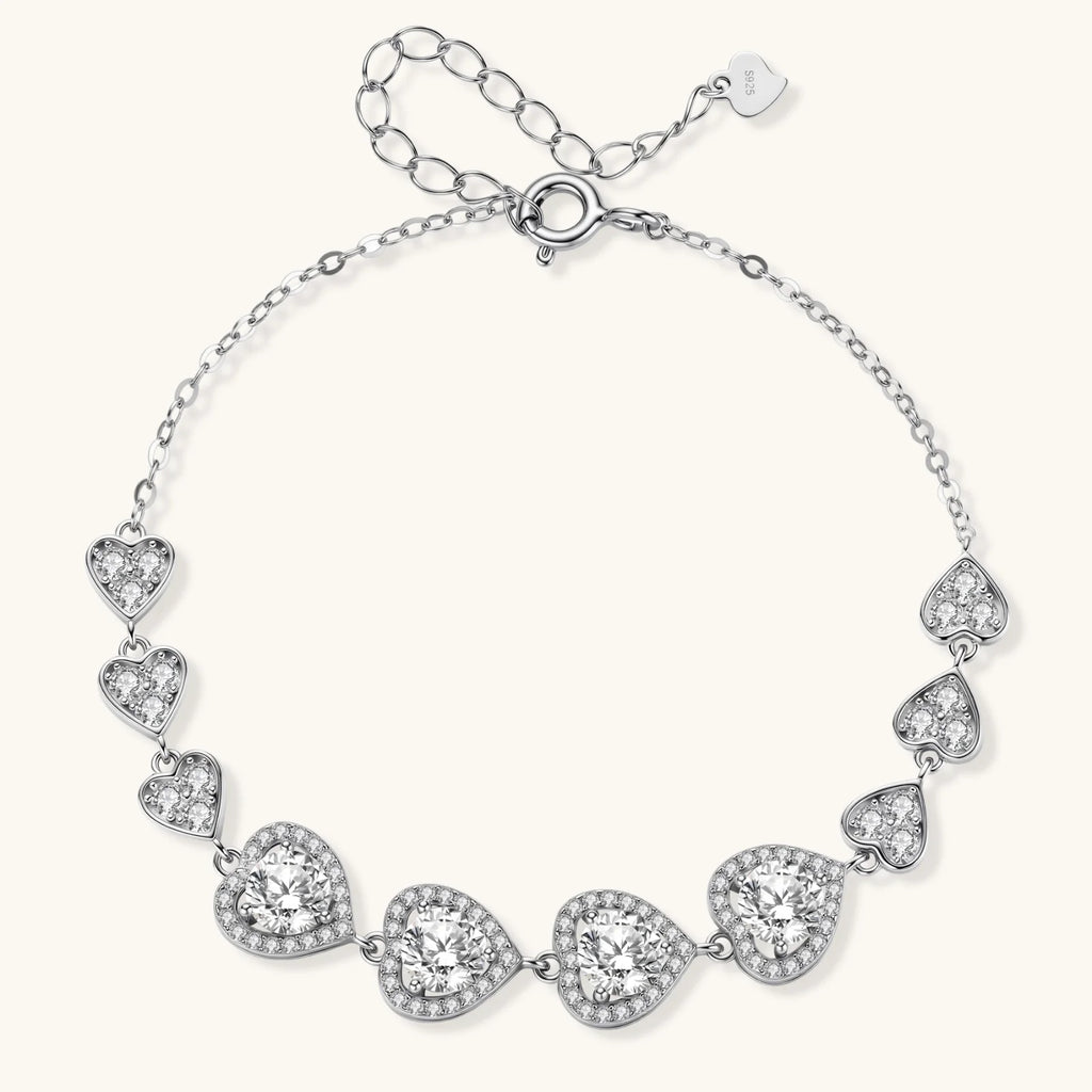 Sterling silver bracelet with graduated heart-shaped links and sparkling moissanite stones in VVS1 clarity on white background.