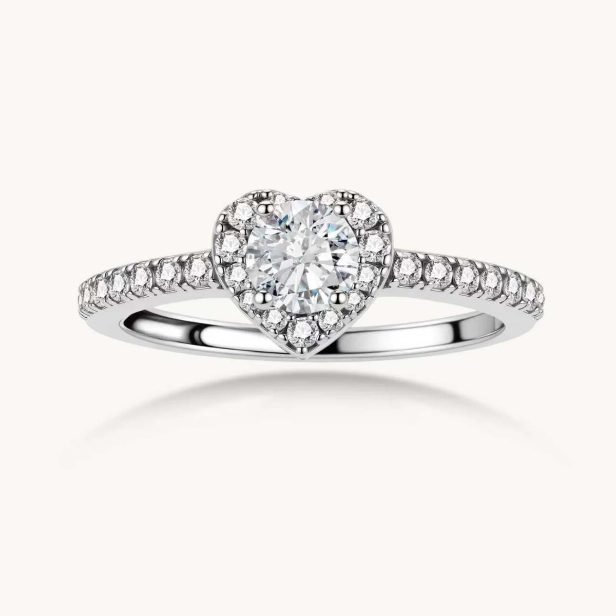 Heart-shaped halo ring with brilliant moissanite center stone surrounded by smaller crystals in sterling silver setting