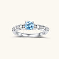 Geometric sterling silver ring with light blue moissanite center stone and square diamond accents on white background