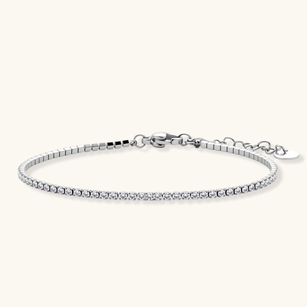 Silver stainless steel tennis bracelet with a single row of clear round zircon stones, lobster clasp, and adjustable extender chain.