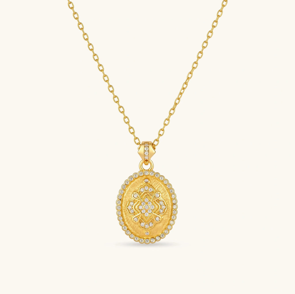Oval gold coin pendant with pave CZ mandala motif and beaded border on an 18K gold-plated cable chain.