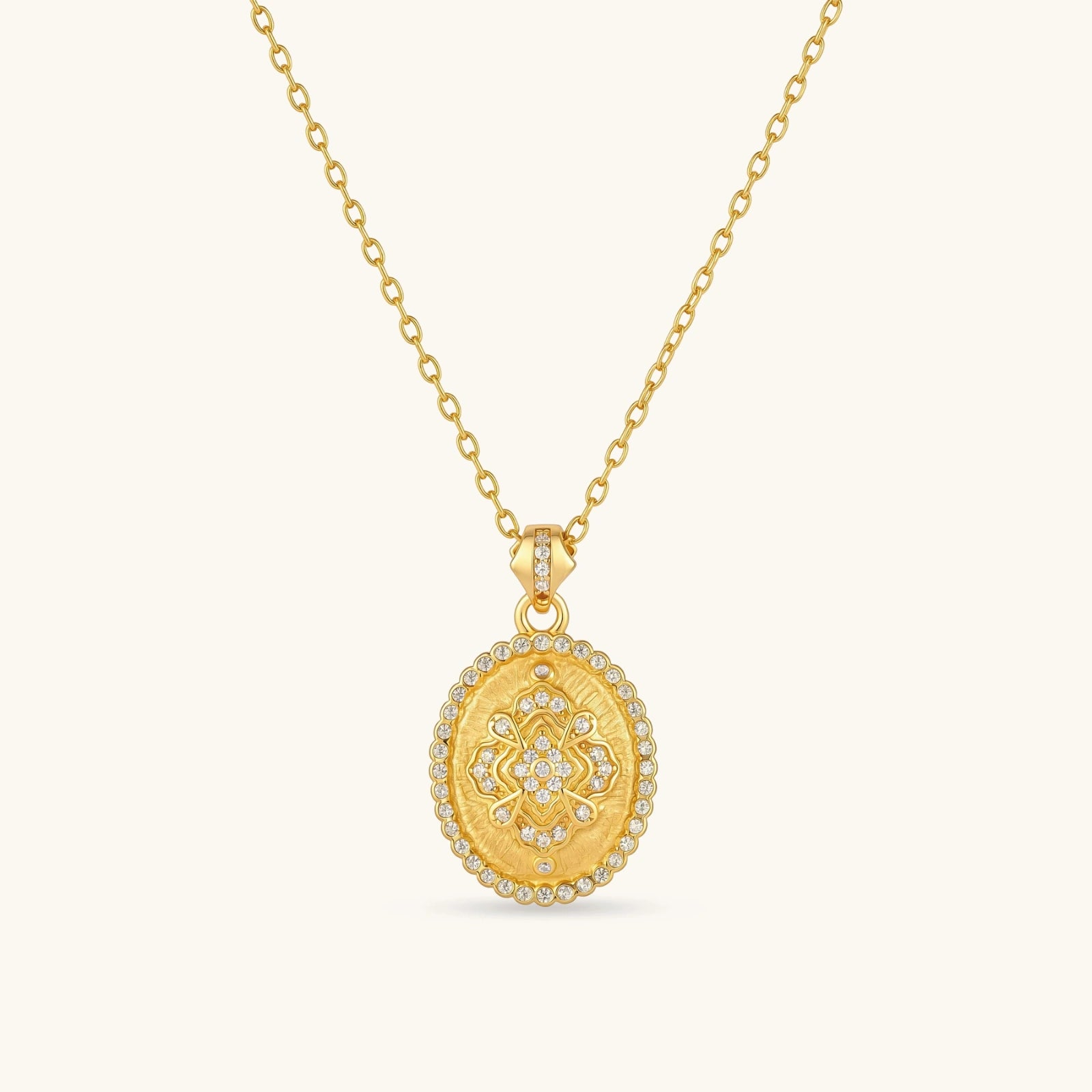 Oval gold coin pendant with pave CZ mandala motif and beaded border on an 18K gold-plated cable chain.